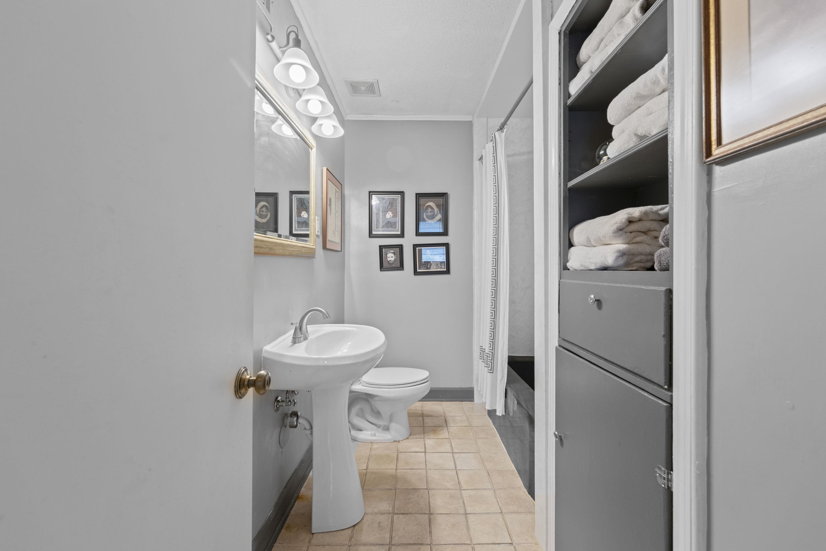 219 North Rose Road Memphis, TN 38117 - Photo 20 of 30 The shared bathroom comes complete with tile flooring, pedestal sink, tub/shower combination, and storage.