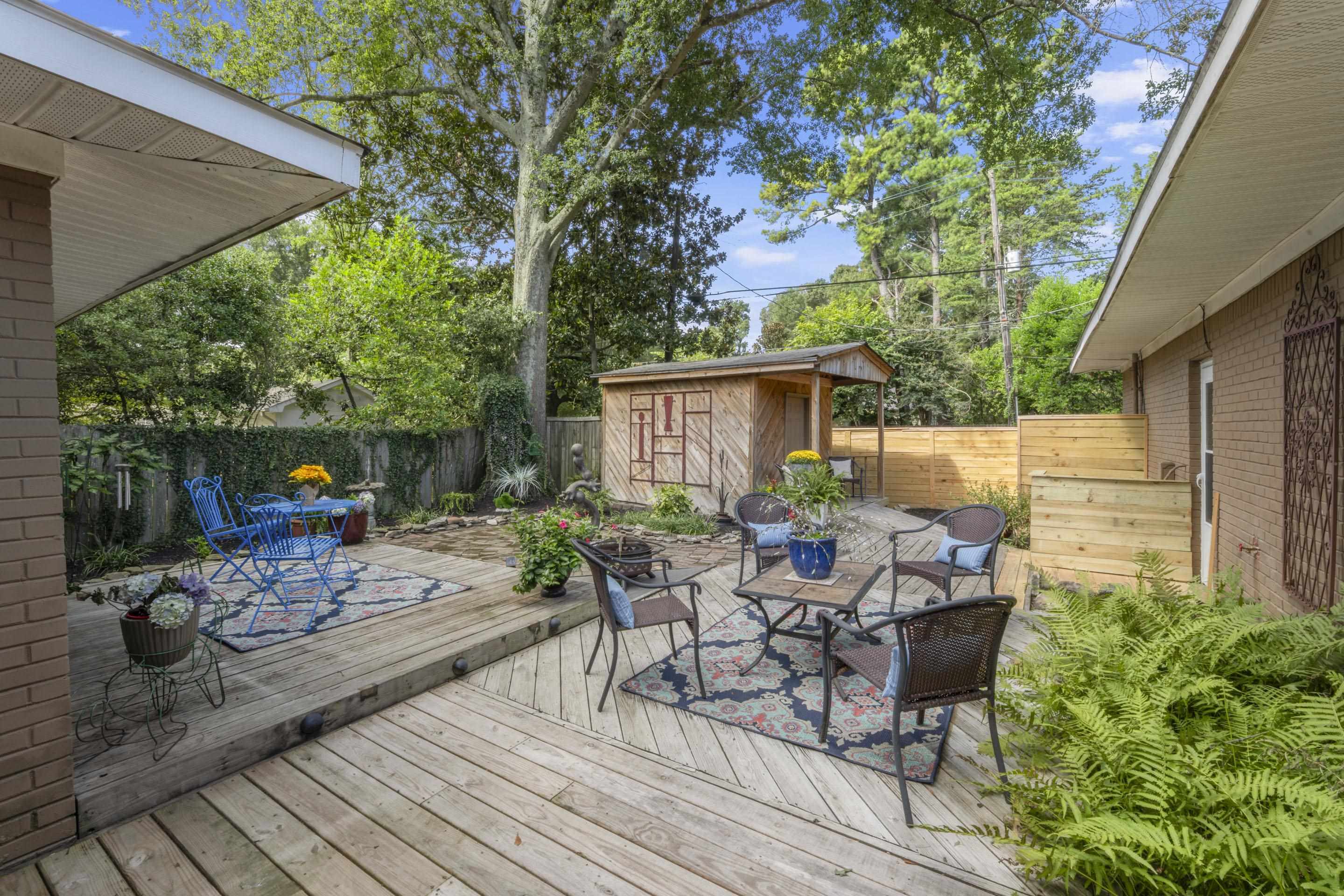 219 North Rose Road Memphis, TN 38117 - Photo 22 of 30 Step outside to your private fenced backyard, featuring lush landscaping, decks, a full-length dog-run, and an 8×12 storage building with electrical power.