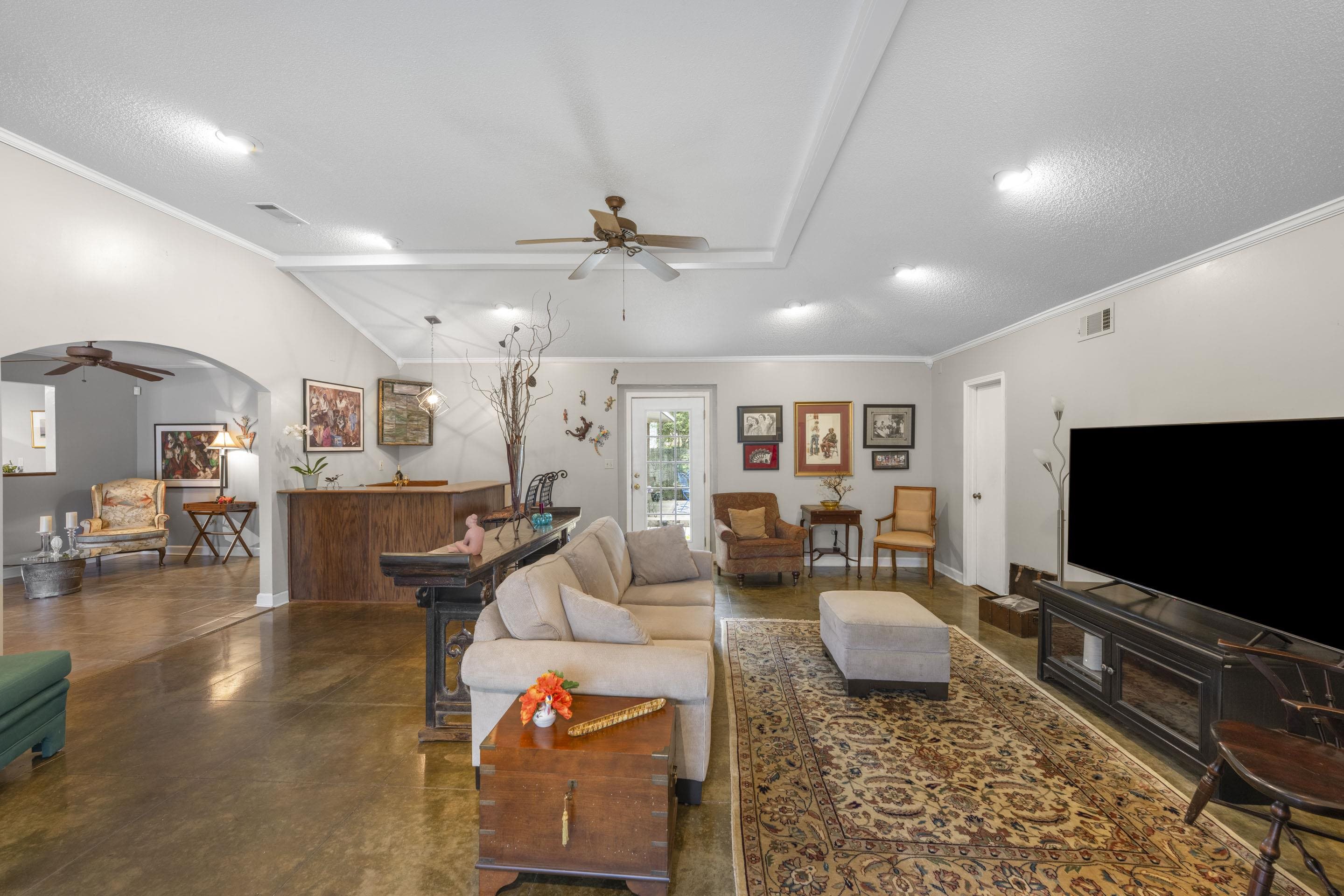 219 North Rose Road Memphis, TN 38117 - Photo 5 of 30 The sitting room flows into the spacious great room, where scored concrete floors, recessed lighting, and a built-in wet bar create an ideal setting for hosting.