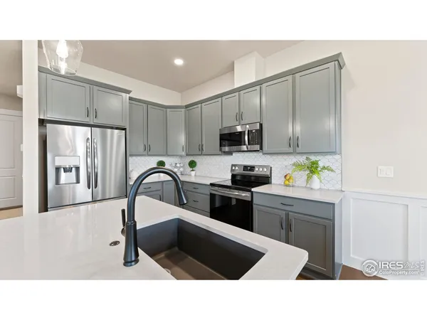 a kitchen with a refrigerator sink and white cabinets