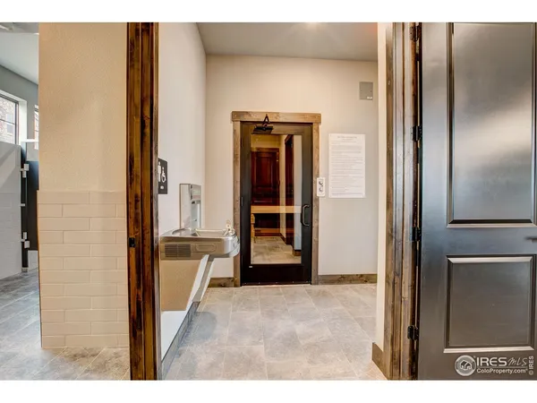 a view of a hallway with wooden floor and a living room