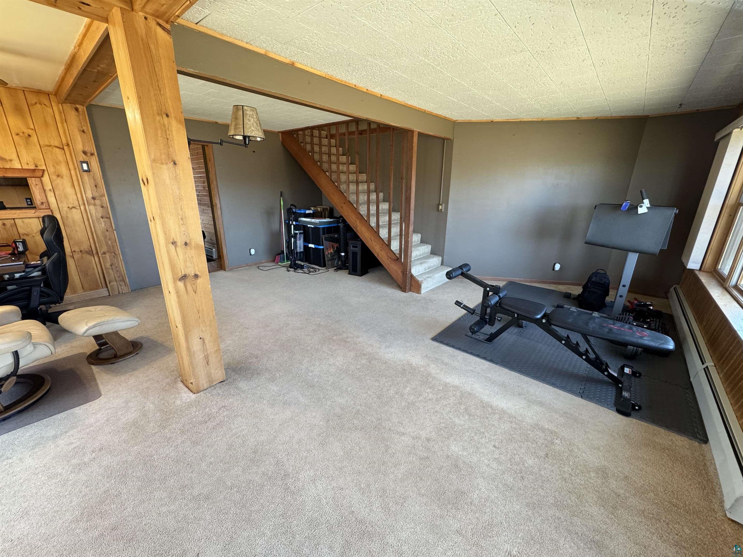 4897 Swanson Drive Maple, WI 54854 - Photo 14 of 25 Spacious room featuring light-toned carpeting and wood-paneled walls