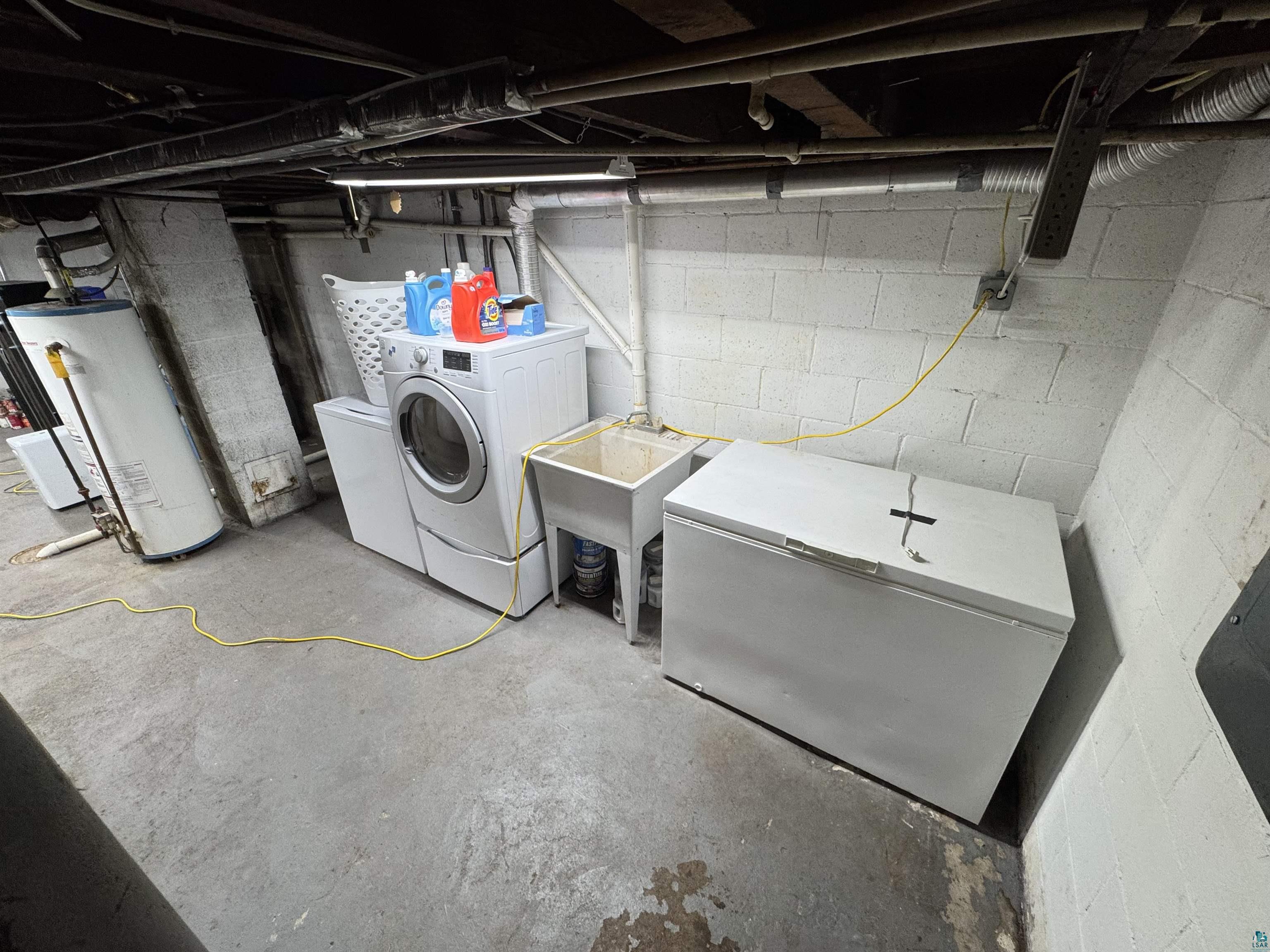 4897 Swanson Drive Maple, WI 54854 - Photo 19 of 25 Laundry area with a utility sink, a front-loading washing machine, and exposed overhead utilities