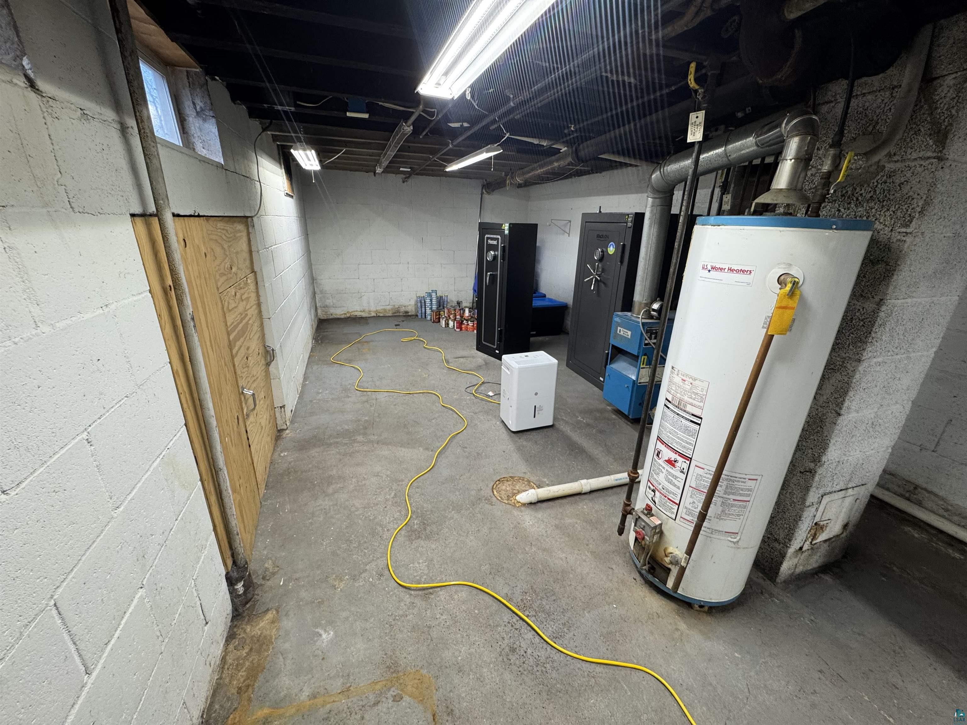 4897 Swanson Drive Maple, WI 54854 - Photo 20 of 25 Concrete block walls and concrete flooring define this utility space, featuring exposed overhead piping and fluorescent strip lighting