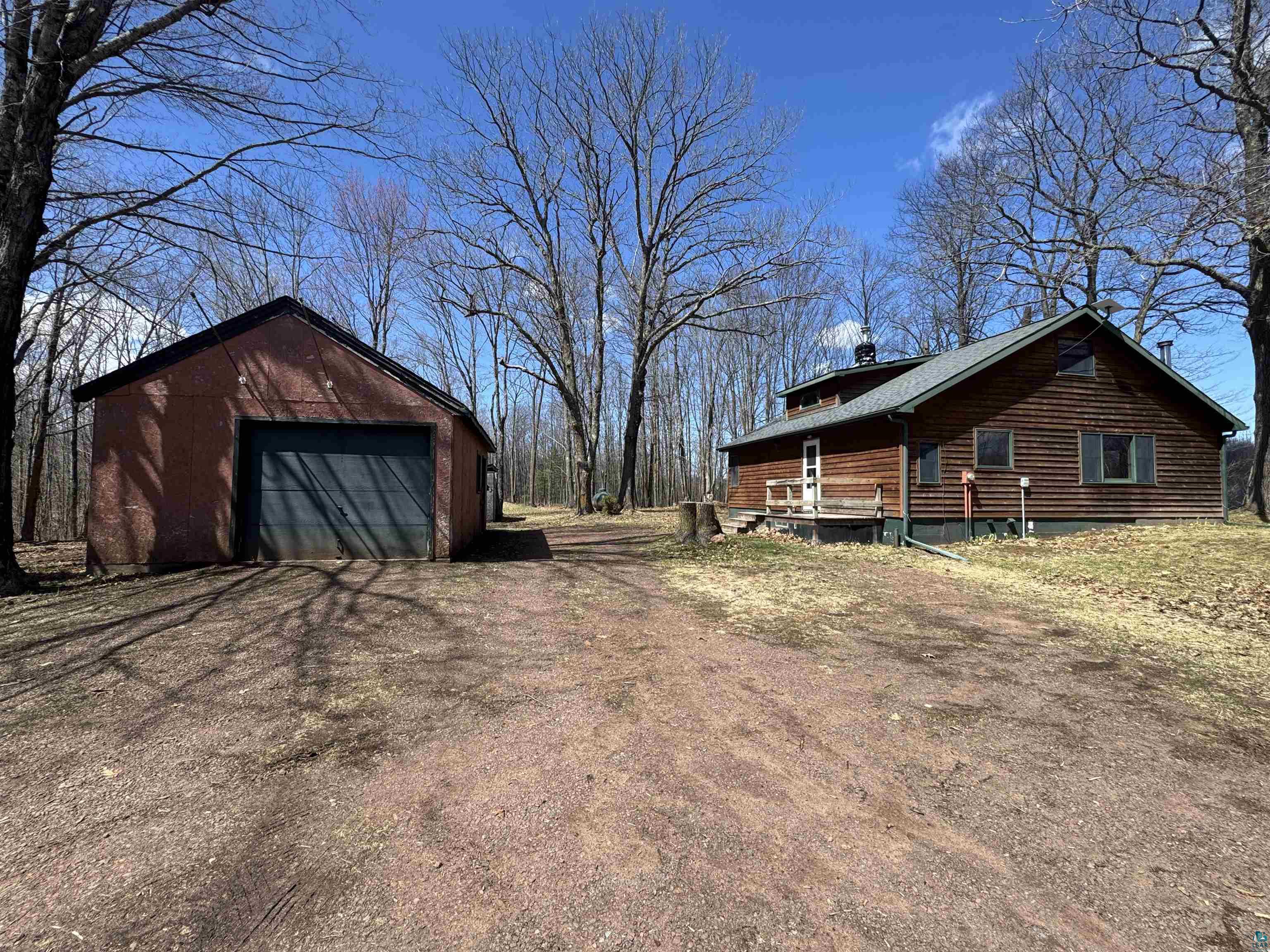 4897 Swanson Drive Maple, WI 54854 - Photo 2 of 25 Wood-sided residence with an inviting front porch and green-shingled roof
