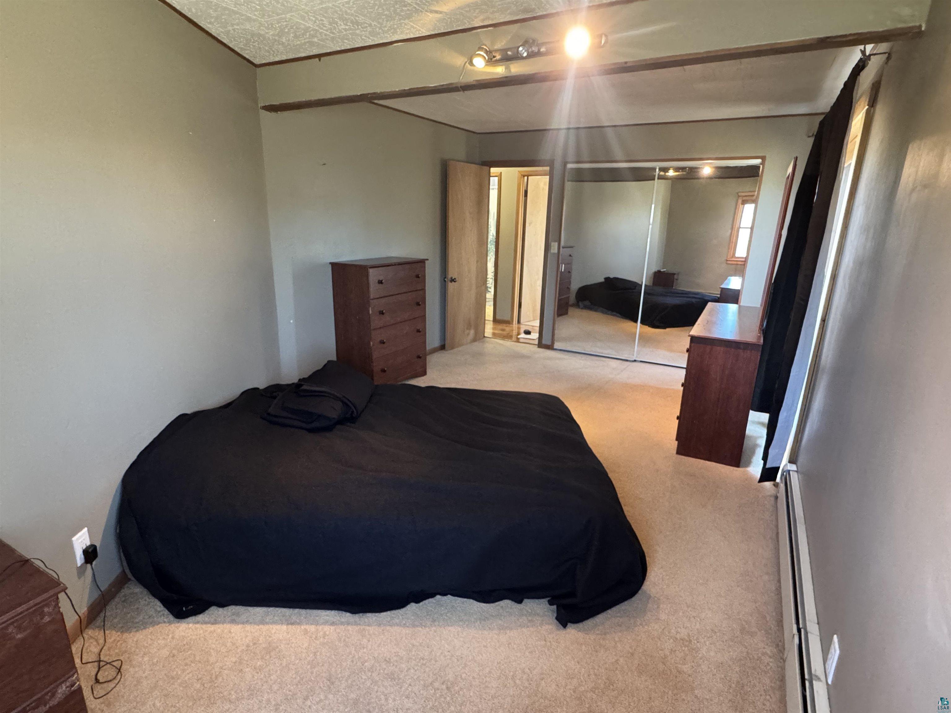 4897 Swanson Drive Maple, WI 54854 - Photo 9 of 25 Carpeted interior space featuring a track light fixture, mirrored sliding closet doors, and light-toned wall paint