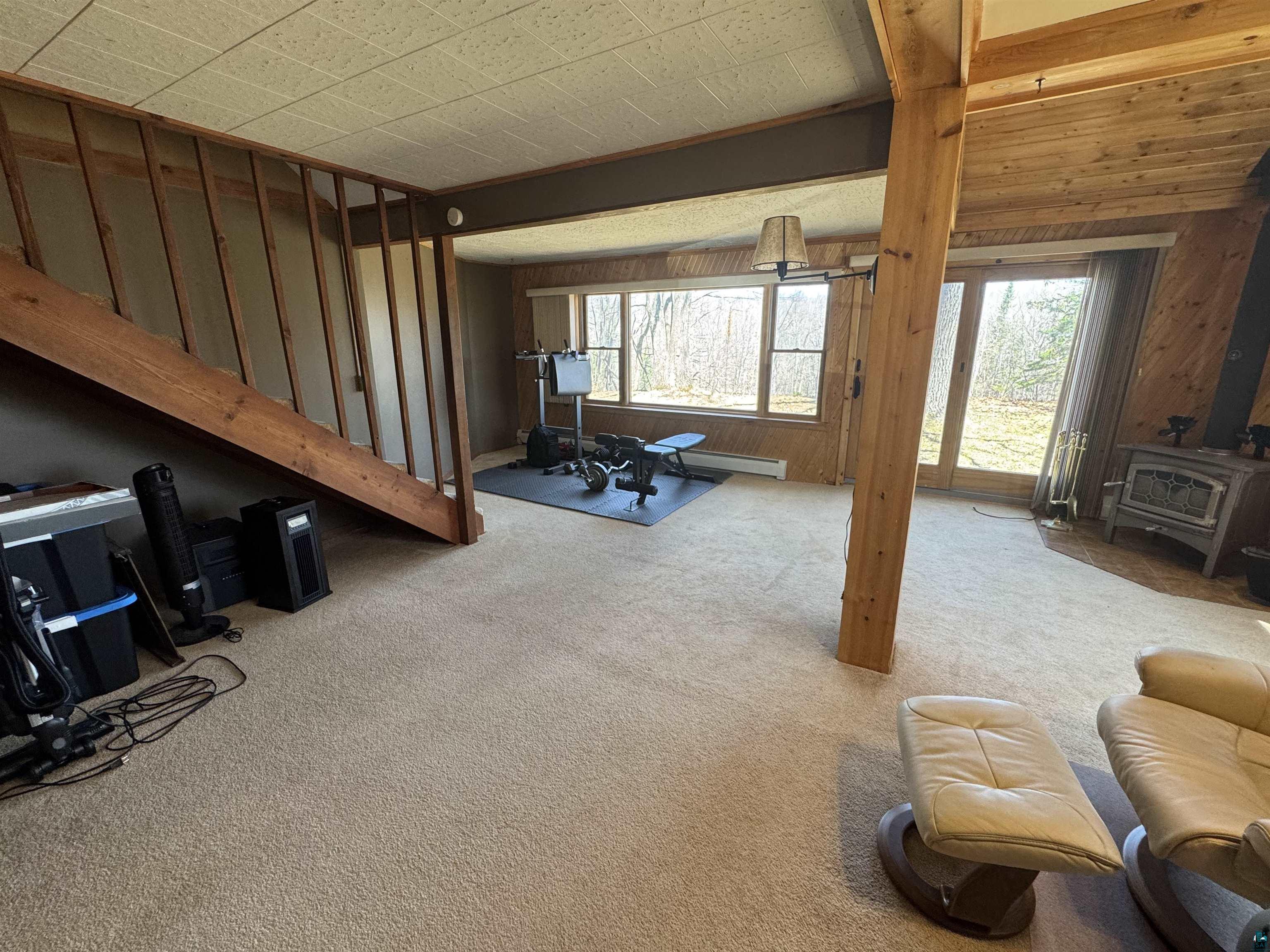 4897 Swanson Drive Maple, WI 54854 - Photo 10 of 25 Spacious living area featuring light-toned carpeting and wood paneling
