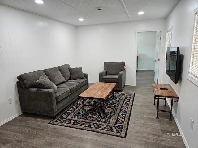 a living room with furniture rug and wooden floor