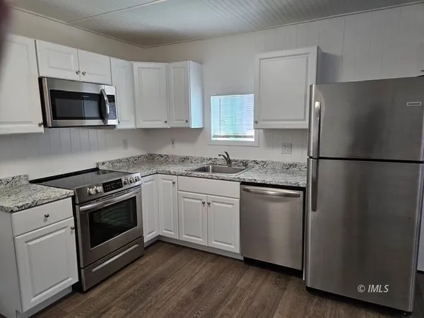 a kitchen with white cabinets and stainless steel appliances