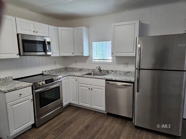 a kitchen with white cabinets and stainless steel appliances