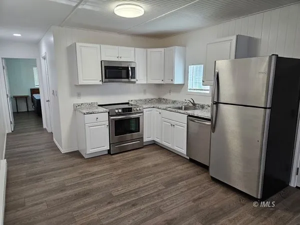 a kitchen with stainless steel appliances a refrigerator sink and microwave