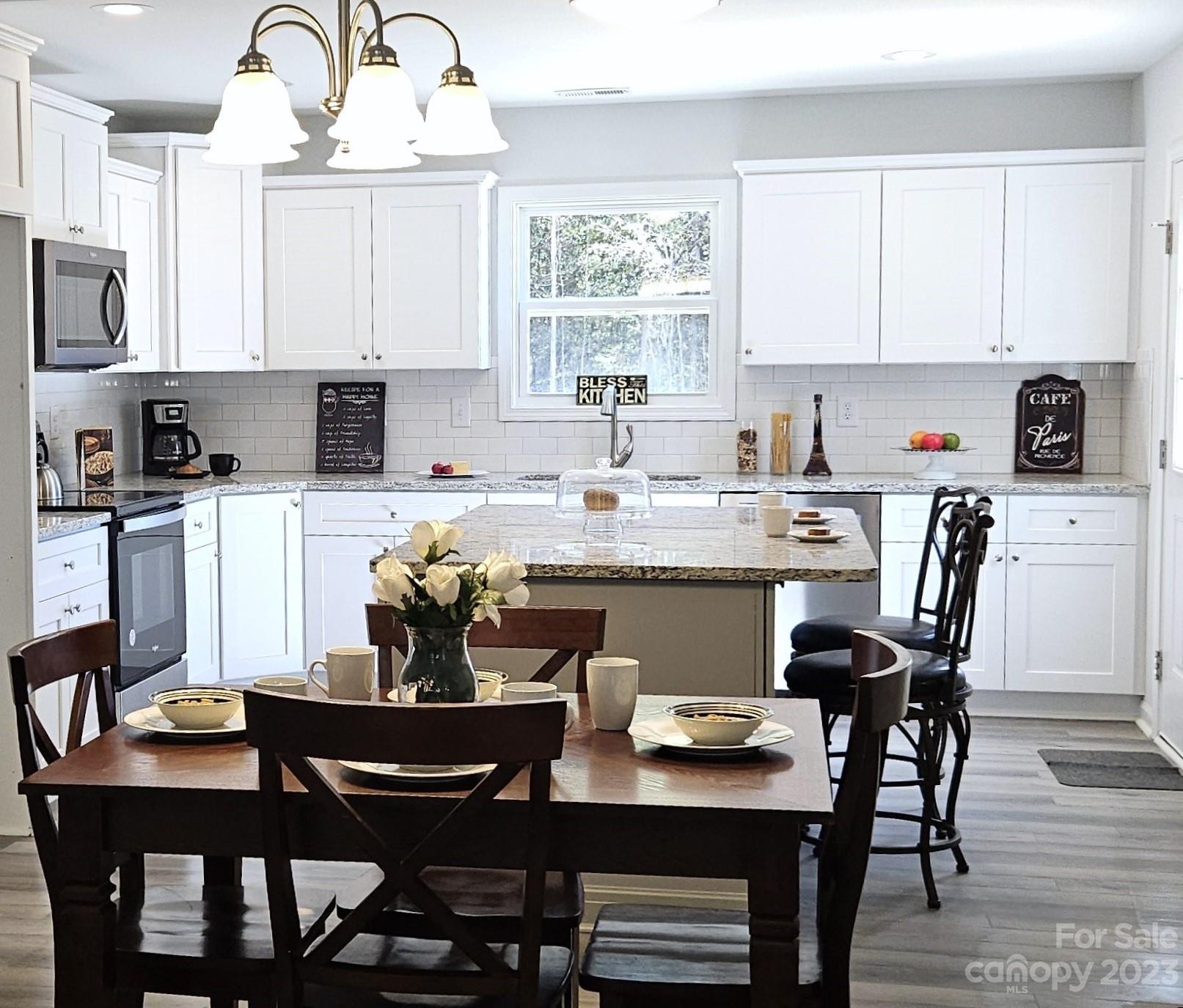 121 Hawkins Loop Salisbury, NC 28144 - Photo 30 of 31 a kitchen with a dining table chairs and white cabinets