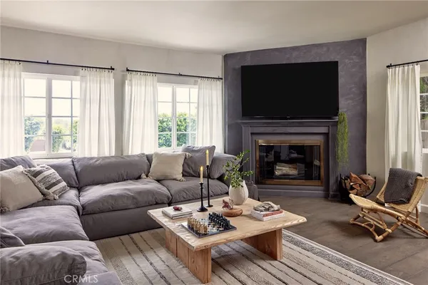 a living room with furniture a flat screen tv and a fireplace