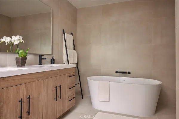 a bathroom with a sink and mirror with bathtub