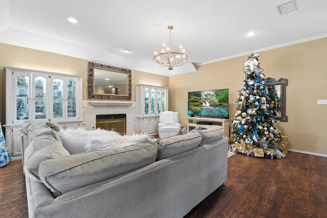 a living room with furniture a chandelier and a fireplace