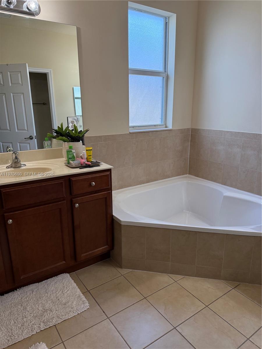 17012 Southwest 91st Street Miami, FL 33196 - Photo 13 of 22 a bathroom with a bathtub and a sink