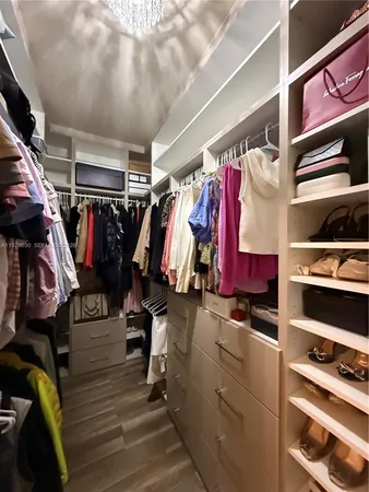a view of walk in closet with clothes and shoes