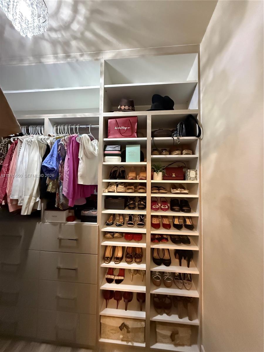 17012 Southwest 91st Street Miami, FL 33196 - Photo 17 of 22 a view of walk in closet with clothes and shoes