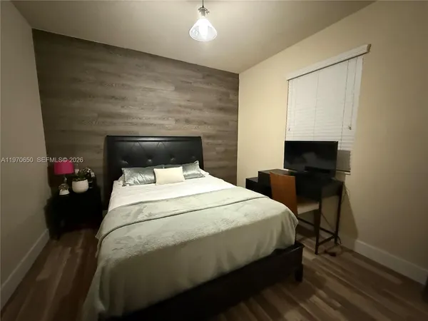 a bedroom with a bed and a potted plant