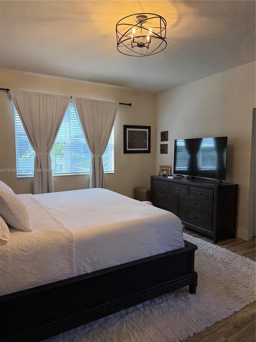 17012 Southwest 91st Street Miami, FL 33196 - Photo 10 of 22 a bedroom with a large bed and a tv