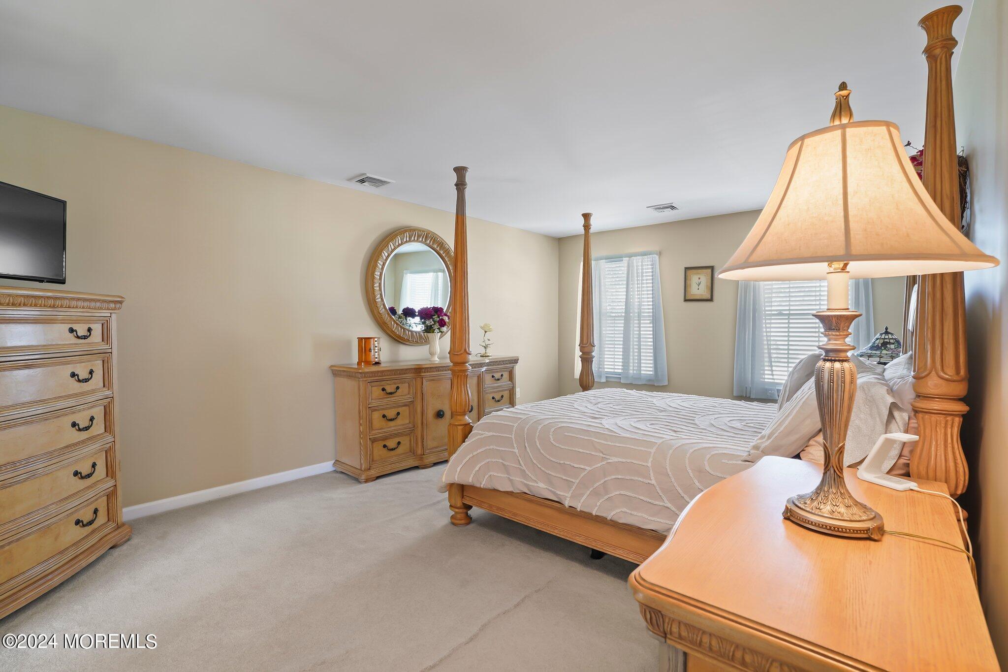 4 Anderson Street Union Beach, NJ 07735 - Photo 29 of 51 a bedroom with a bed a mirror on dresser and a chandelier