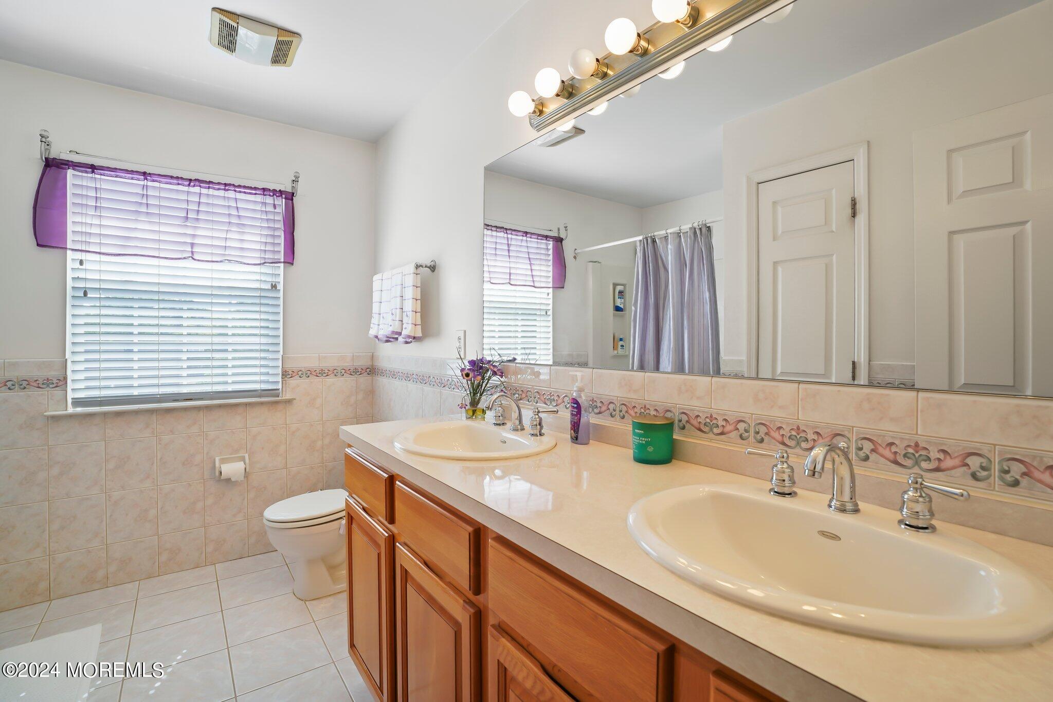 4 Anderson Street Union Beach, NJ 07735 - Photo 30 of 51 a bathroom with a double vanity sink a toilet and a mirror