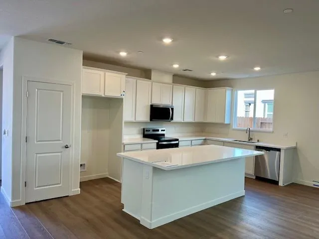a kitchen with wooden floors and white cabinets
