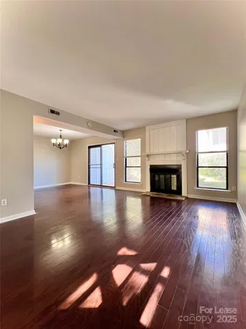 a view of empty room with wooden floor and fireplace
