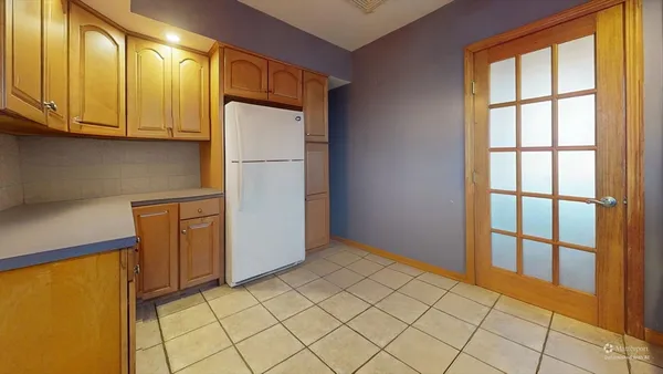 a view of a refrigerator in kitchen and a window