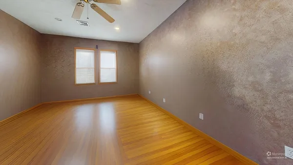 a view of a room with a chandelier fan and windows