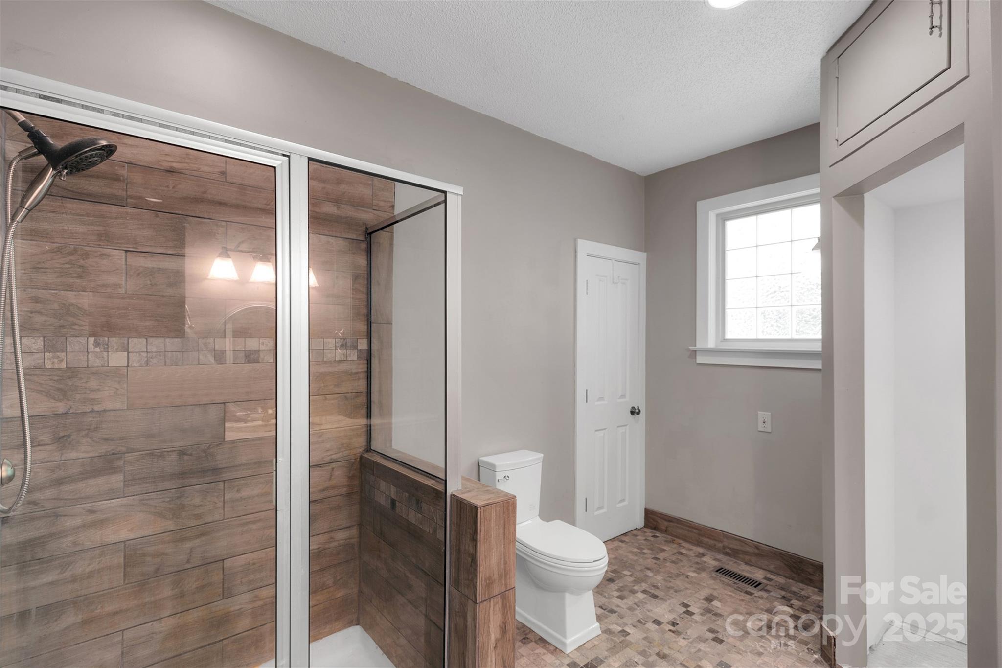 3333 Roberta Road Concord, NC 28027 - Photo 24 of 47 a bathroom with a granite countertop toilet a sink and shower