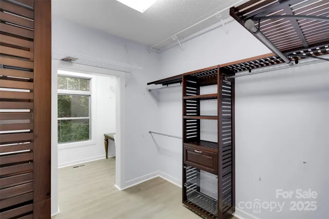a view of a hallway with wooden floor and a living room
