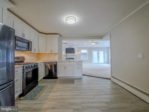 a kitchen with granite countertop a refrigerator stove top oven and sink