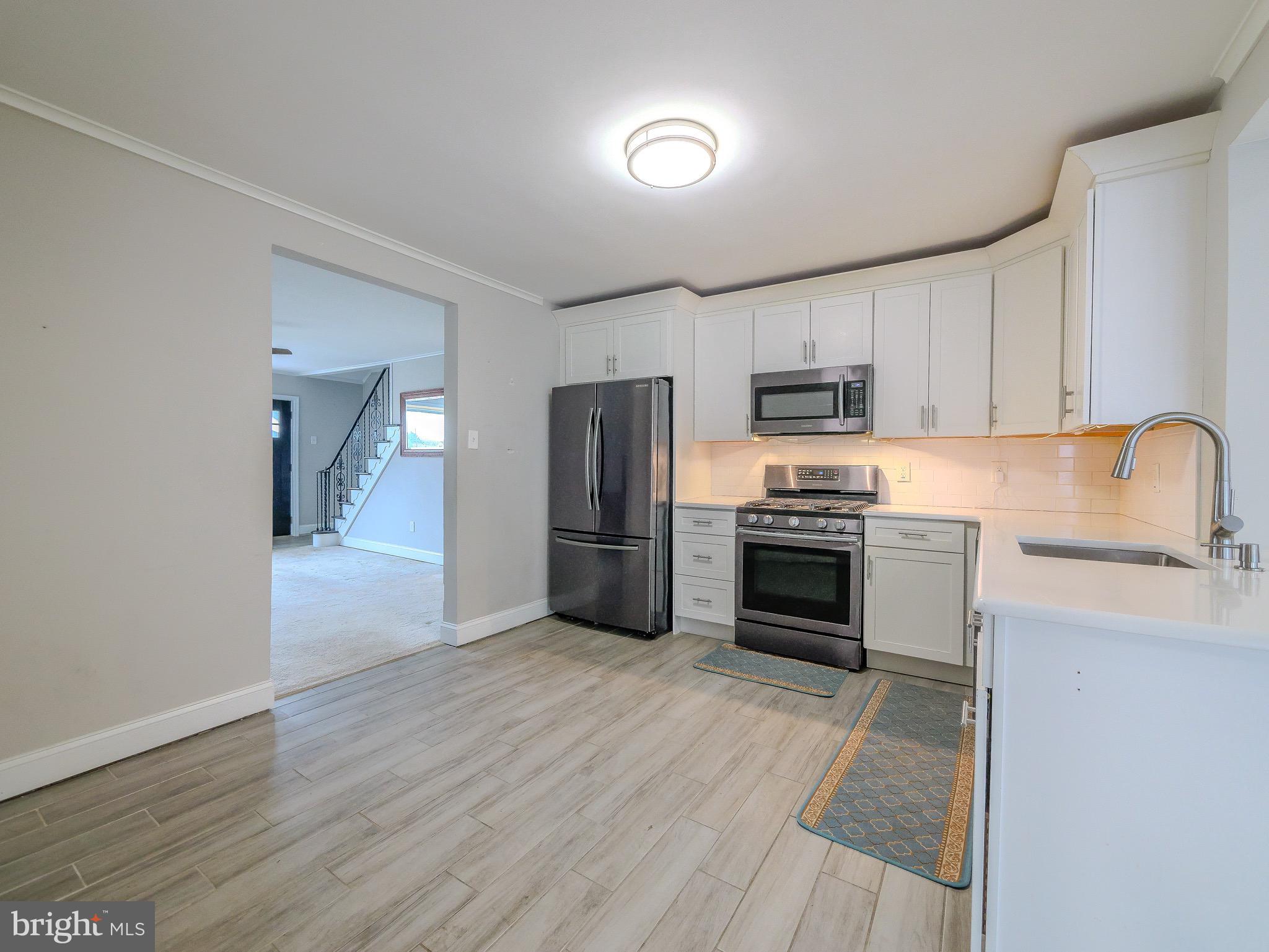 520 Lindsay Street Ridley Park, PA 19078 - Photo 9 of 53 a kitchen with granite countertop a refrigerator and a stove top oven