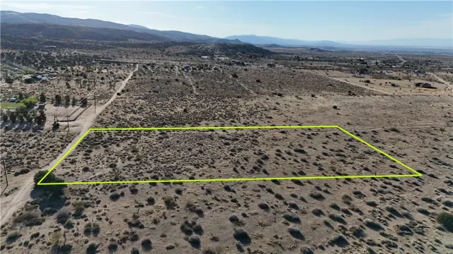 a view of a yard with wooden fence