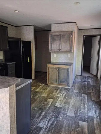 a view of kitchen with granite countertop cabinets and refrigerator