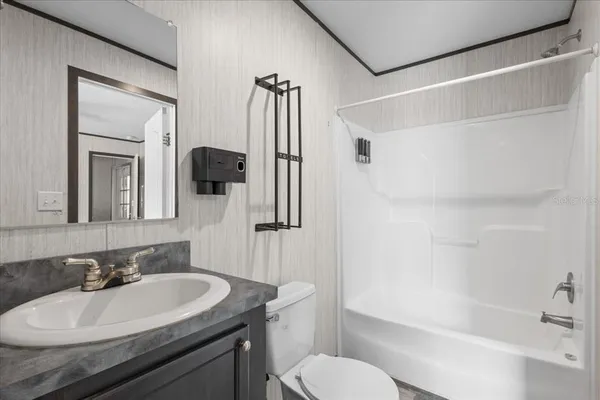 a bathroom with a sink toilet vanity and shower