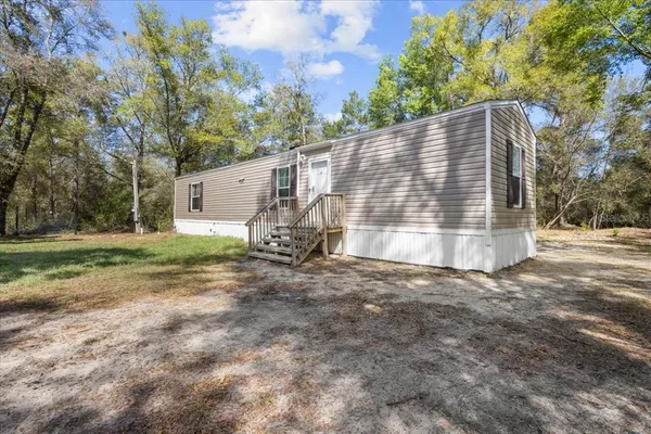 a backyard of a house with table and chairs