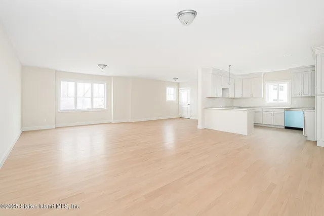 a view of a kitchen with a sink and dishwasher stove top oven with white cabinets