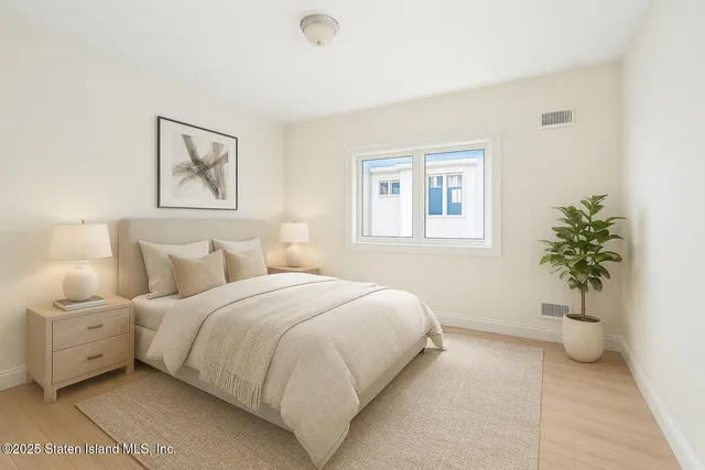 a bedroom with a bed and a potted plant