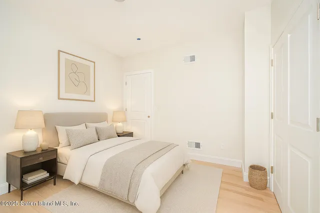 a bedroom with a bed and a painting on the wall