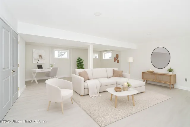 a living room with furniture a rug a lamp and a large window