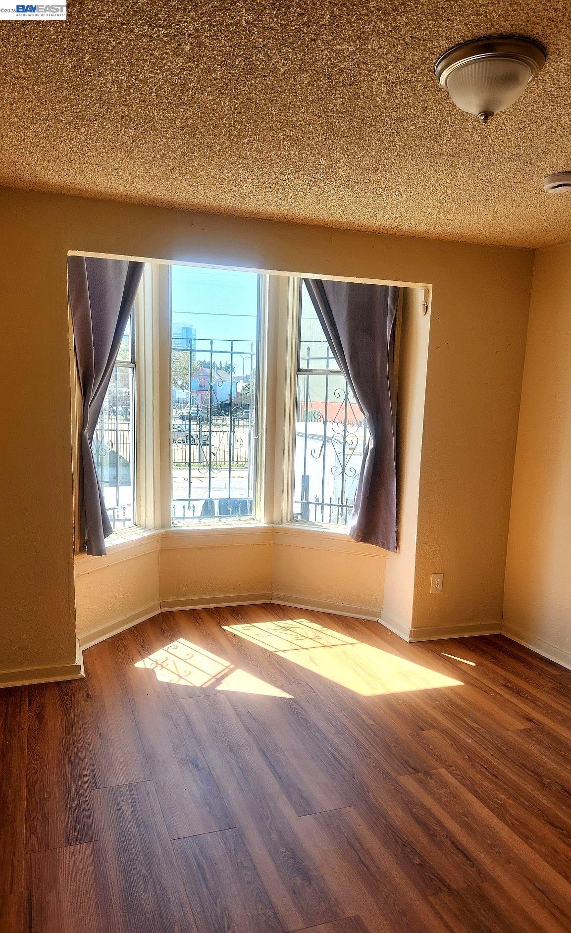 874 Isabella Street Oakland, CA 94607 - Photo 6 of 9 an empty room with wooden floor and windows
