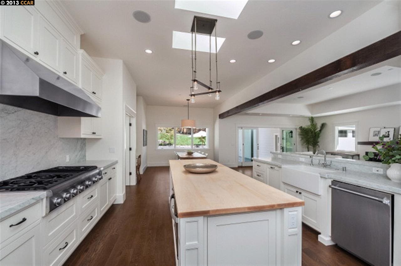 3848 Happy Valley Road Lafayette, CA 94549 - Photo 9 of 27 a kitchen with a stove a sink dishwasher and white cabinets with wooden floor