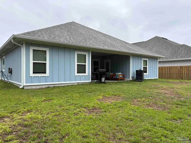 a view of a house with backyard and porch
