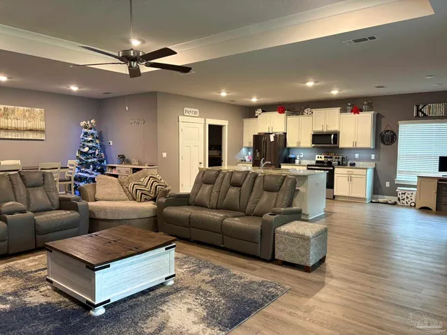 a living room with furniture and a wooden floor