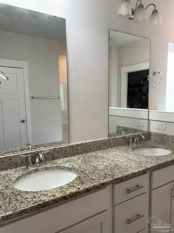 a bathroom with a granite countertop sink double and mirror