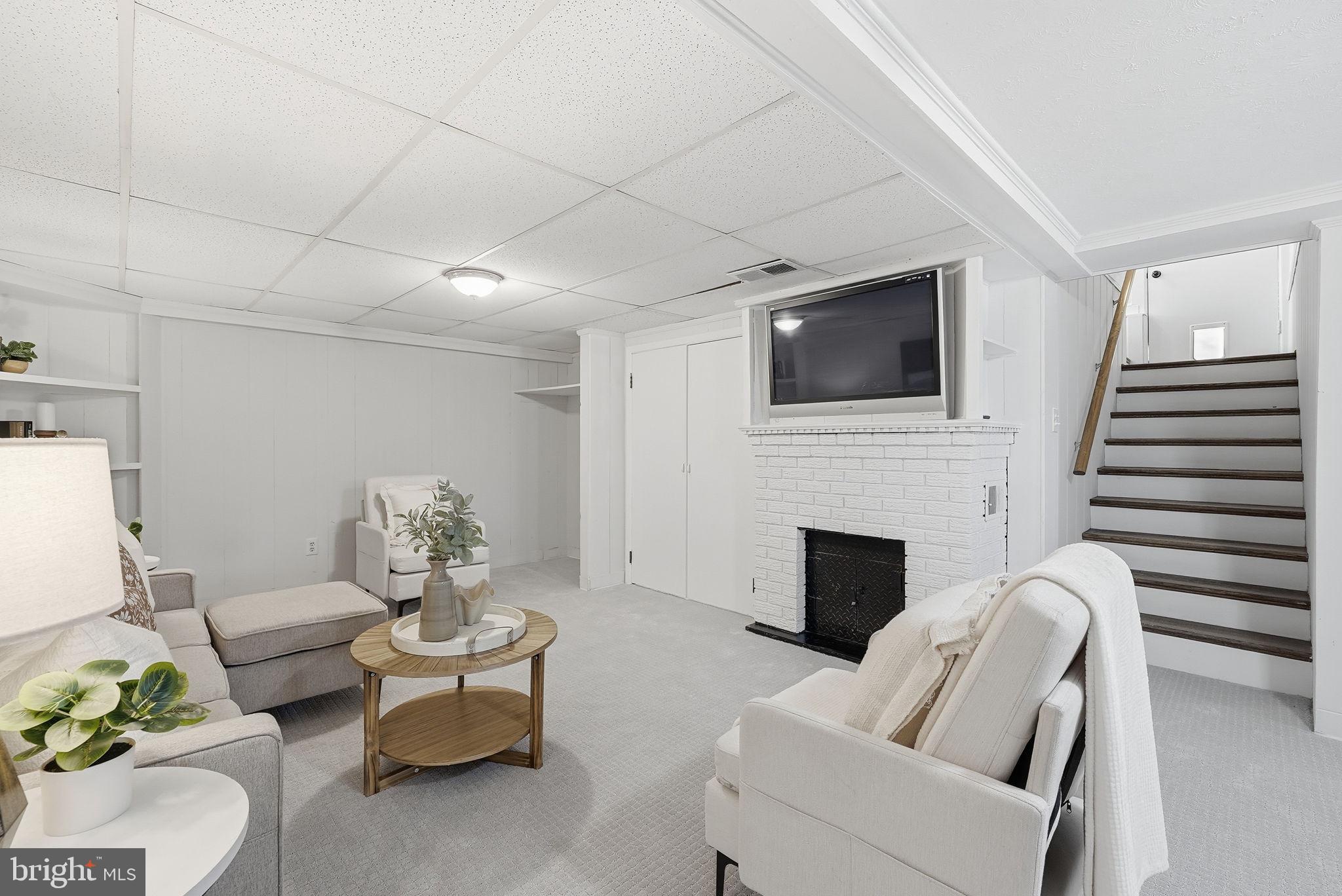 17509 Black Rock Road Germantown, MD 20874 - Photo 17 of 26 a living room with furniture a fireplace and a flat screen tv