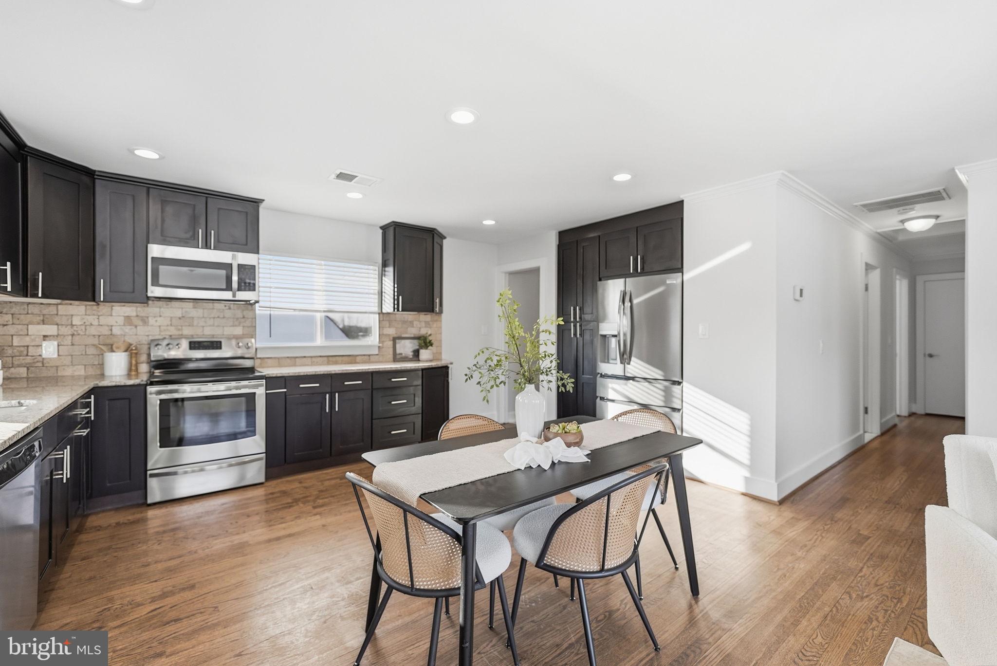 17509 Black Rock Road Germantown, MD 20874 - Photo 7 of 26 a kitchen with stainless steel appliances kitchen island granite countertop a stove a sink a refrigerator white cabinets and wooden floor