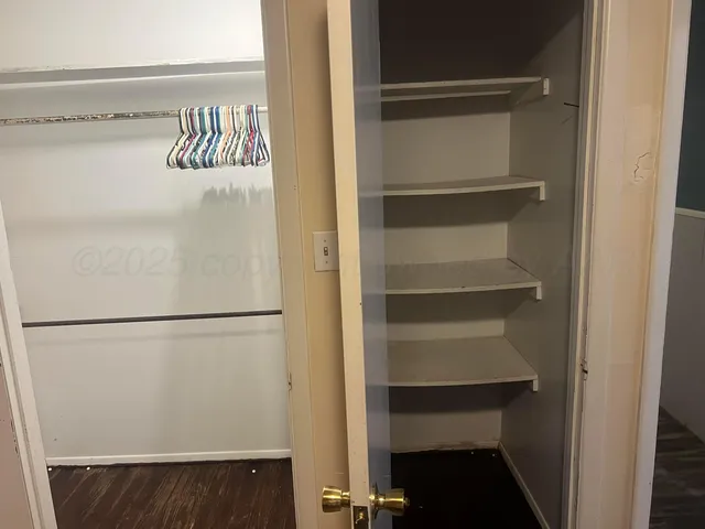 a view of walk in closet with empty racks